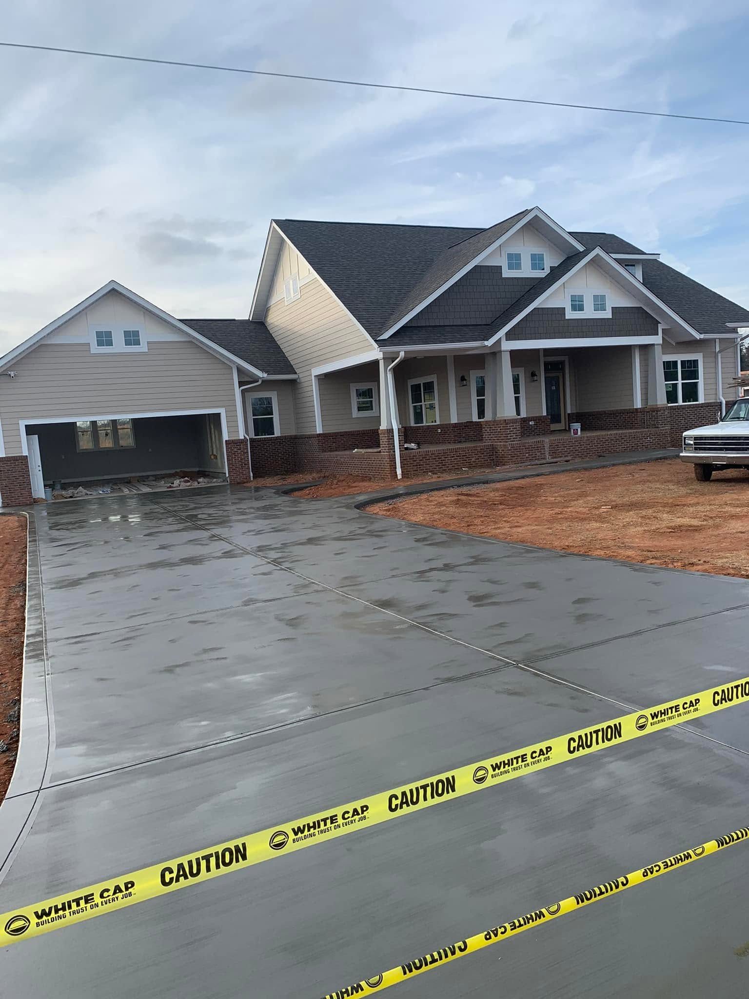 New residential concrete driveway leading to a garage
