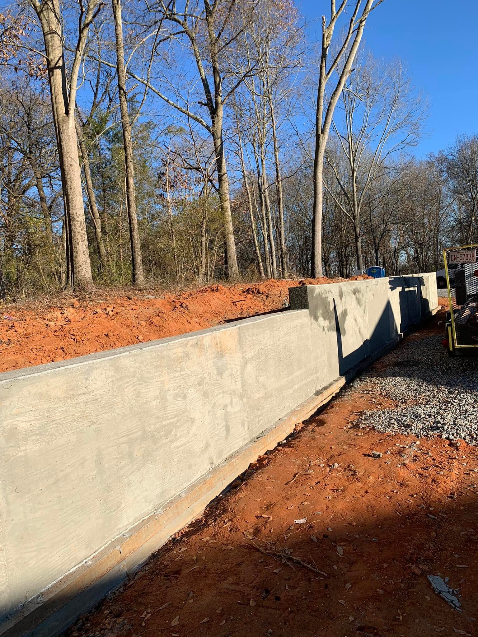 Finished concrete retaining wall supporting a sloped yard